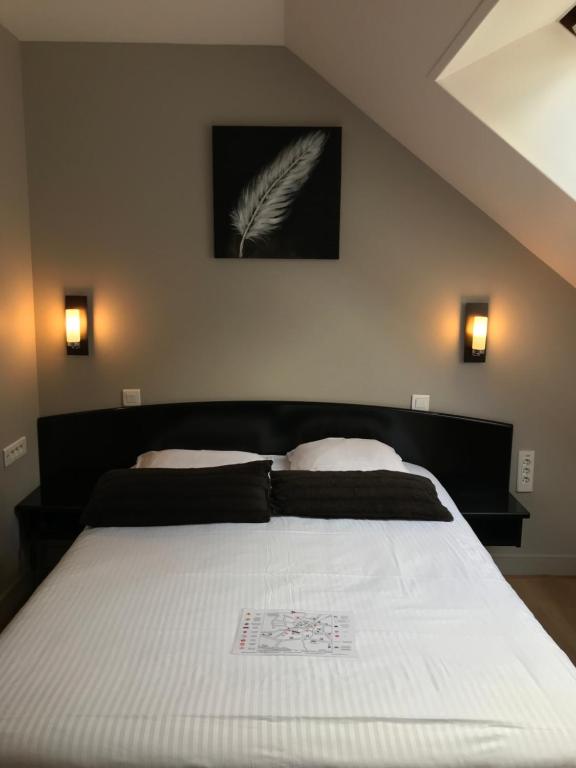 Postel nebo postele na pokoji v ubytování Hôtel Le Bayeux