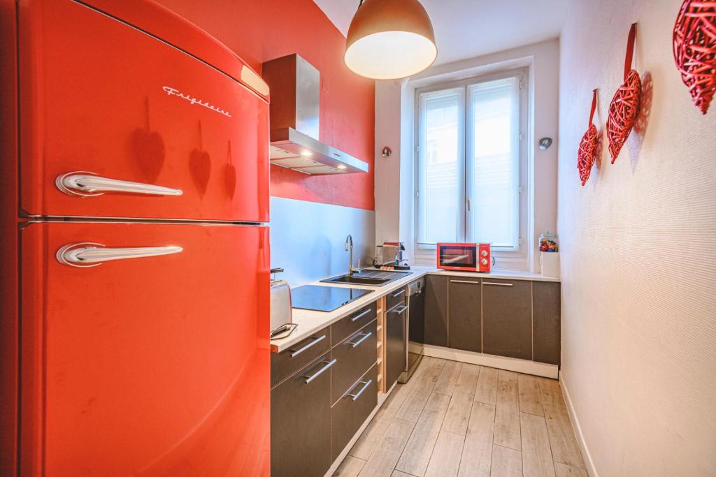 a kitchen with an orange refrigerator and a sink at Zen et Chic in Reims