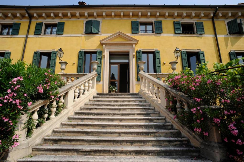 eine Treppe, die zu einem gelben Gebäude mit Blumen führt in der Unterkunft Corte Beatrice in Novaglie