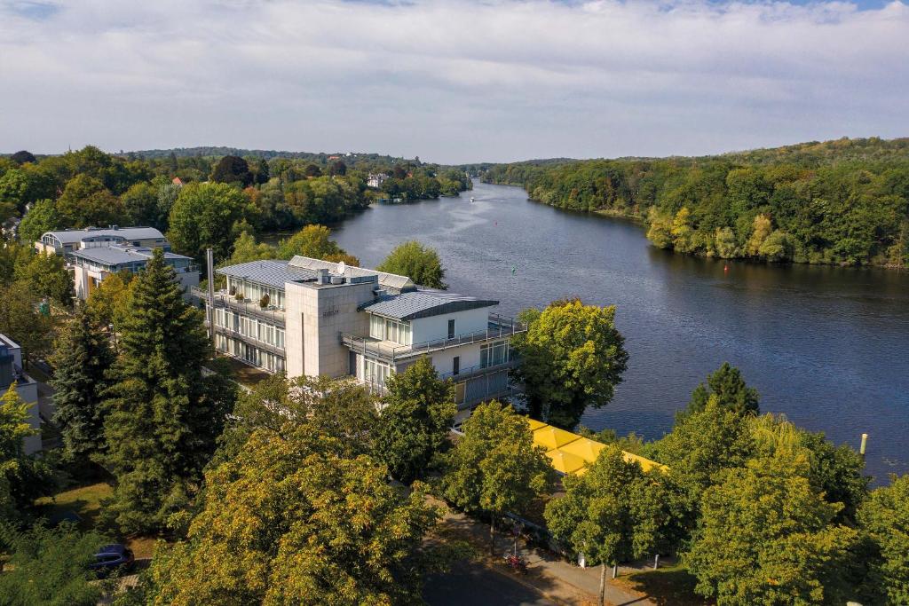 arial view of a river with a building and trees at Seminaris Hotel Potsdam Griebnitzsee in Potsdam