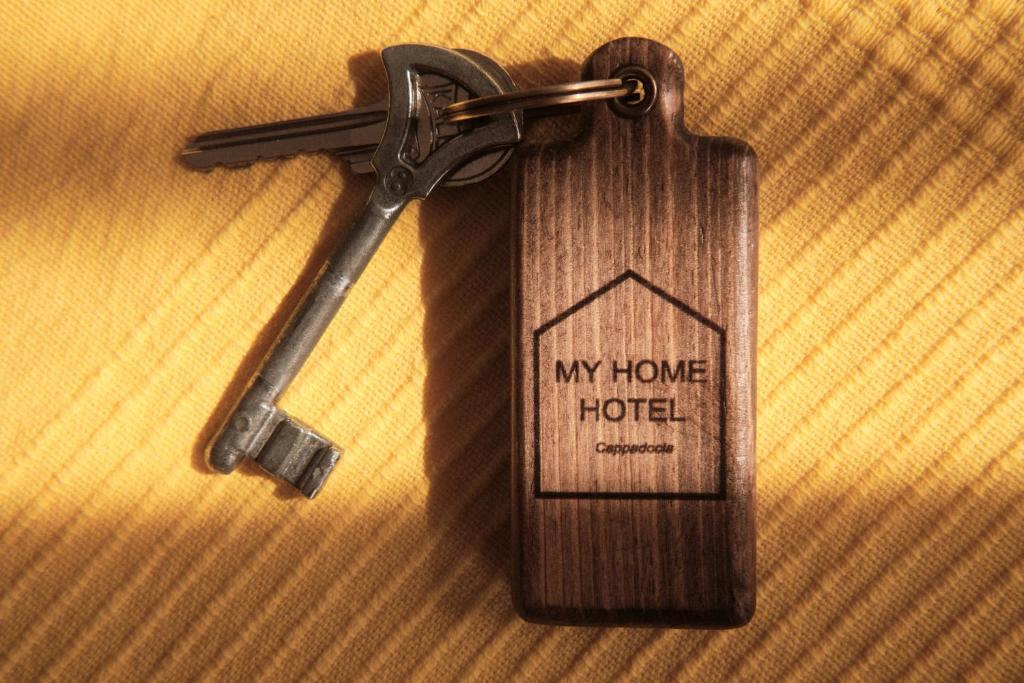 uma chave de casa de madeira com uma etiqueta de hotel em My Home Cappadocia Stone House em Goreme