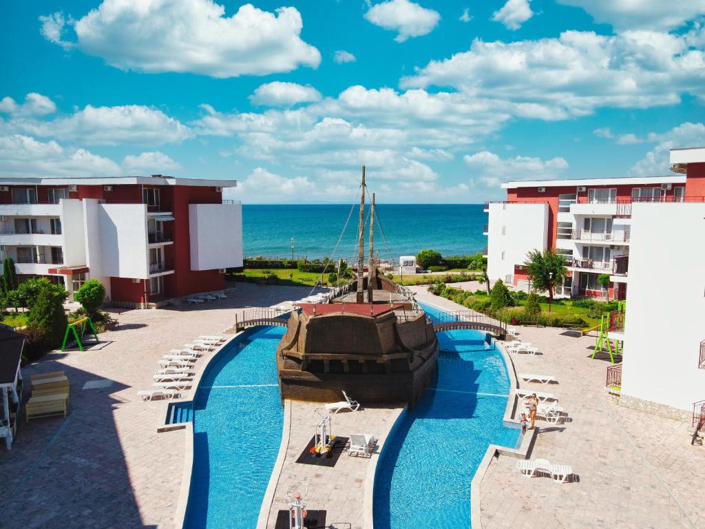 a pool at a resort with a boat in it at Privilege Fort Beach Apartments in Sveti Vlas
