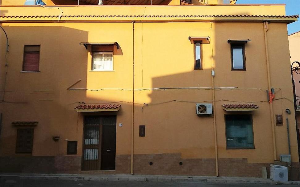 un bâtiment jaune avec une porte sur son côté dans l'établissement Casa Vacanza Trappeto Palermo 2, à Trappeto