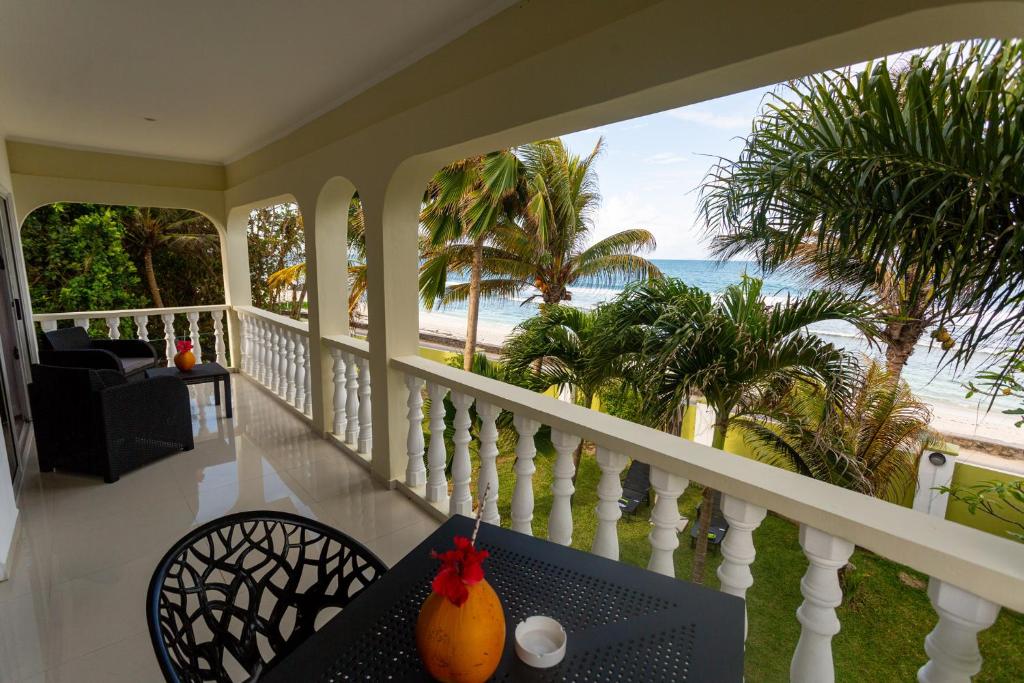 een balkon met een tafel en uitzicht op het strand bij Villa Bella in Mahe