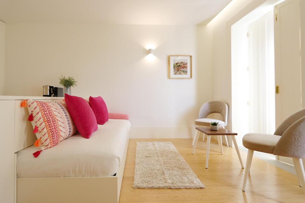 uma sala de estar com um sofá branco com almofadas coloridas em HM - Historical Studio Taipas 3E no Porto