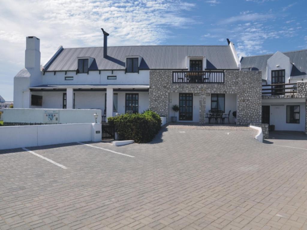 a large white house with a large patio at Whispering Whale in Jacobs Bay