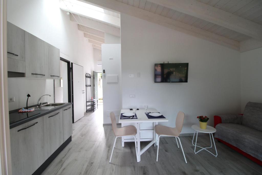 a kitchen and living room with a table and chairs at Agriturismo Nona Emma in Piano Porlezza