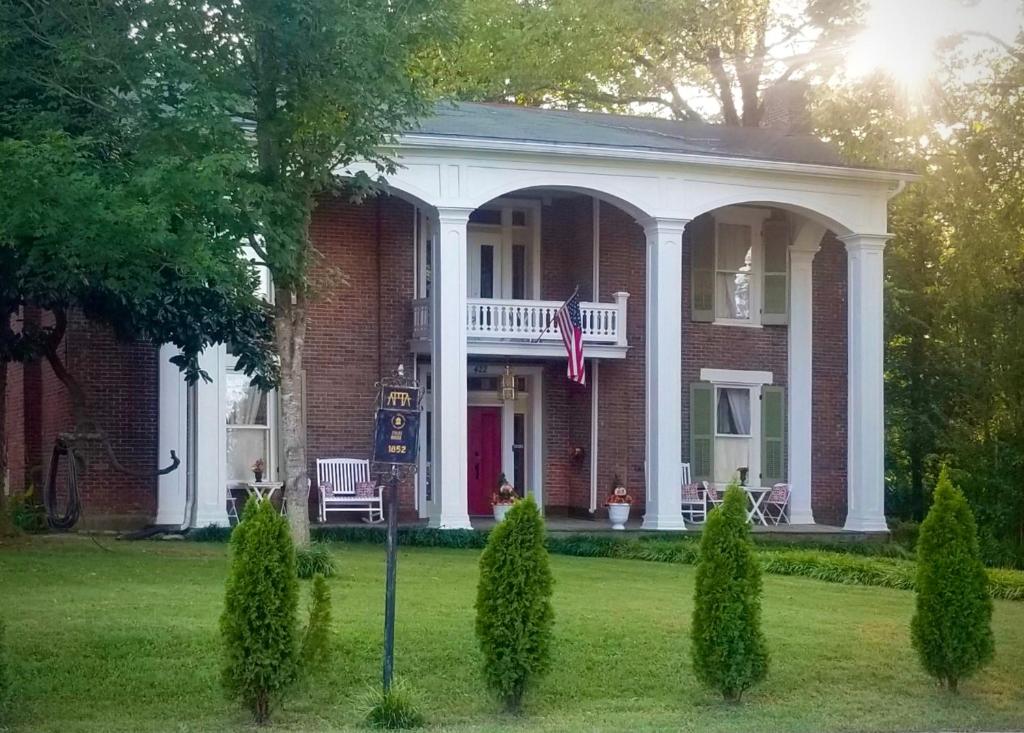 a red brick house with an american flag in the yard at Belmont Inn in Shelbyville