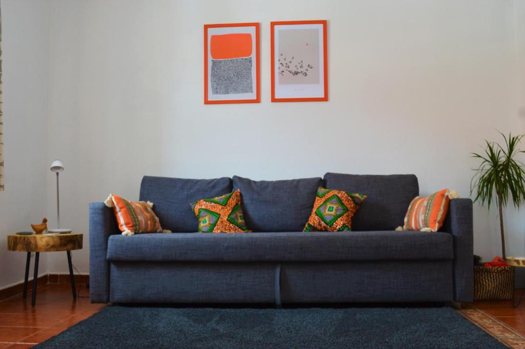 ein blaues Sofa mit Kissen im Wohnzimmer in der Unterkunft Central Tavira apartment, Casa Oliverio in Tavira