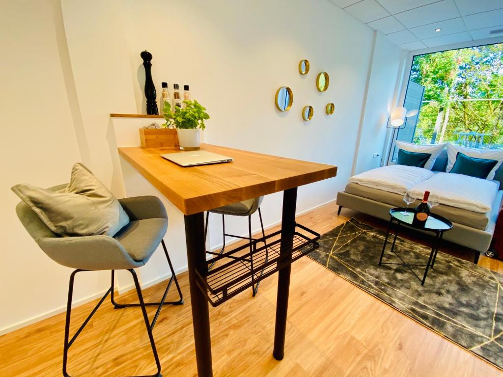 a room with a table and chairs and a bed at Business-Apartments A40 Friedrichshafen in Friedrichshafen