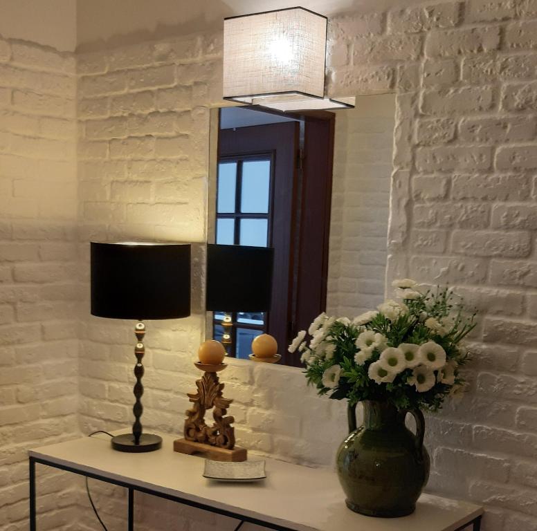 une table avec un vase de fleurs et une lampe dans l'établissement Casa O'lado, à Golegã