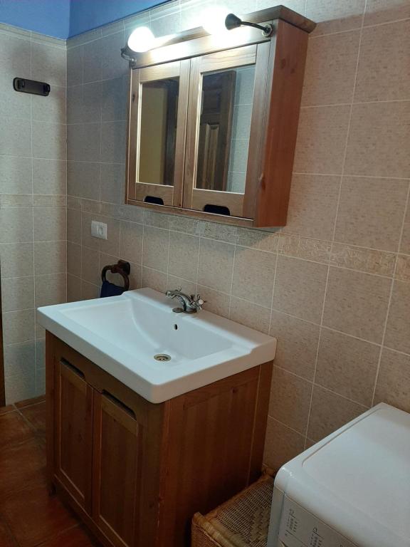 a bathroom with a sink and a mirror and a toilet at APARTAMENTOS MATARRANYA in Valderrobres