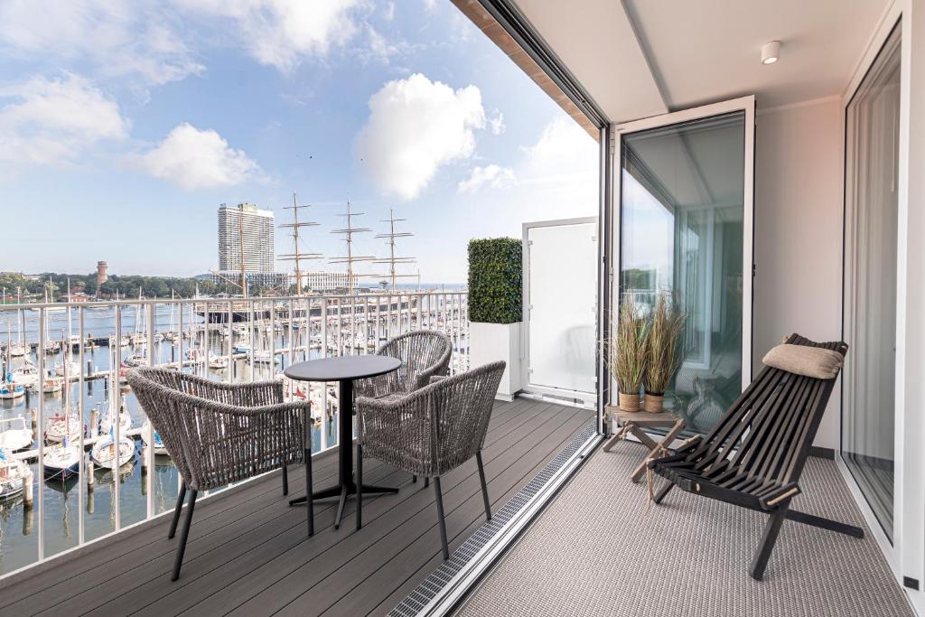 a balcony with a table and chairs and a view of the water at SlowDown Travemünde in Travemünde