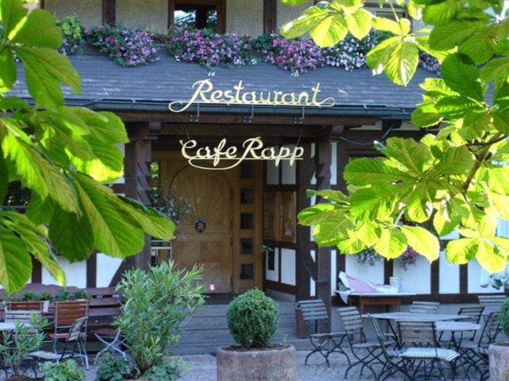 ein Restaurant mit Tischen und Stühlen vor einem Gebäude in der Unterkunft Hotel Restaurant Café Rapp in Königsfeld im Schwarzwald