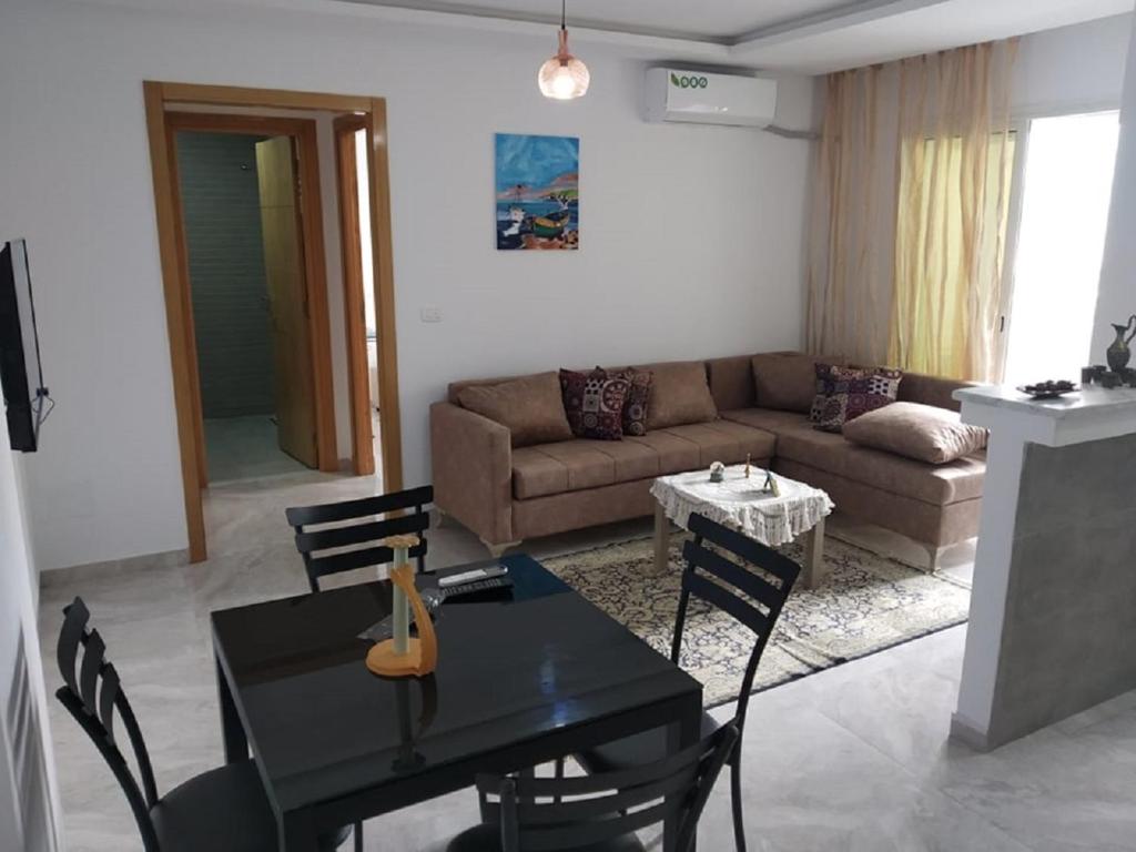 a living room with a table and a couch at Apparts zayatine in Tunis