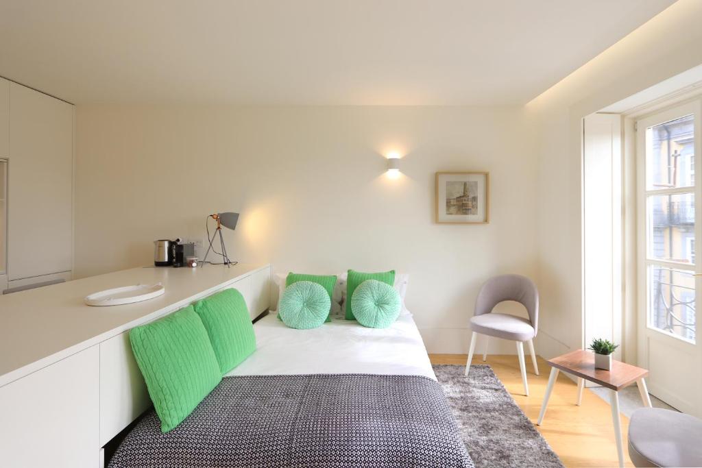 Habitación con cama con almohadas verdes y barra. en HM - Historical Studio Taipas 2D, en Oporto