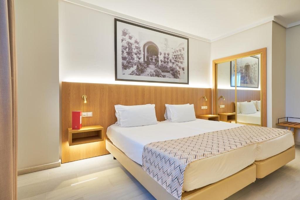 Un dormitorio con una cama grande en una habitación. en Exe Ciudad de Córdoba, en Córdoba