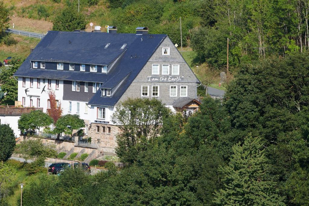 een groot wit huis met een zwart dak bij The Conscious Farmer Bed and Breakfast Sauerland in Willingen