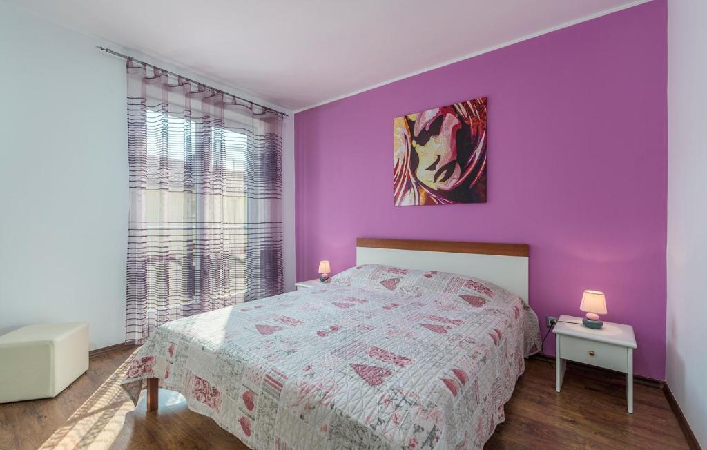 a bedroom with purple walls and a bed with a white bedspread at Apartment Marino in Poreč