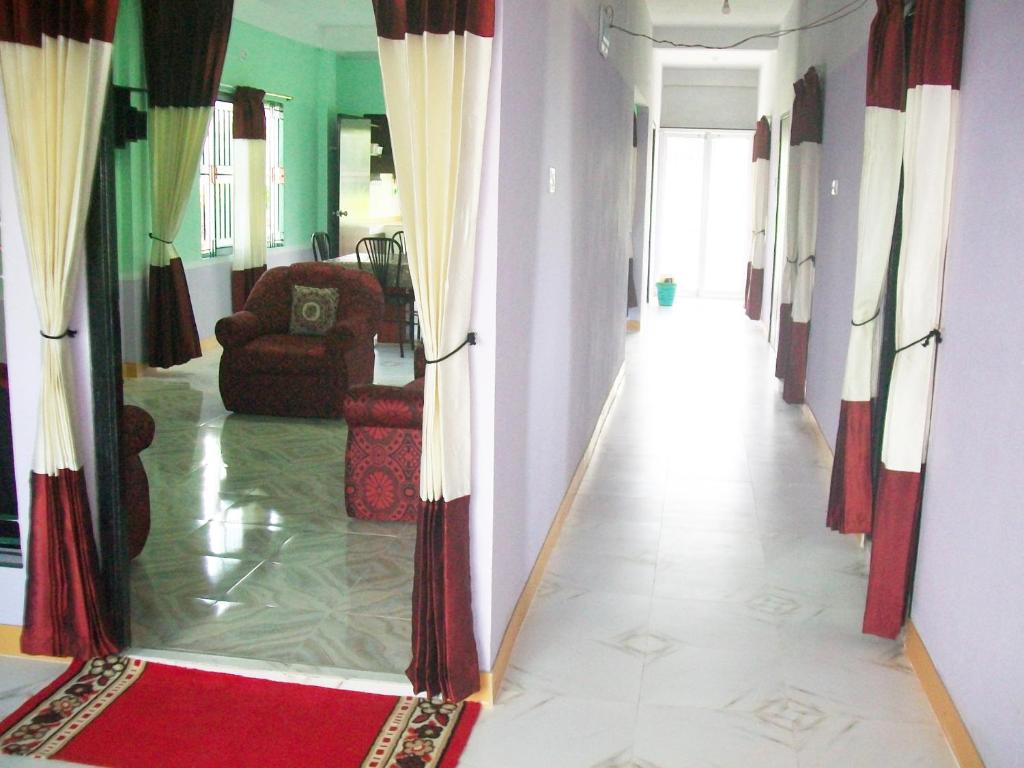 a hallway with a living room with a red rug at ApartmenT - Homestays in Sylhet