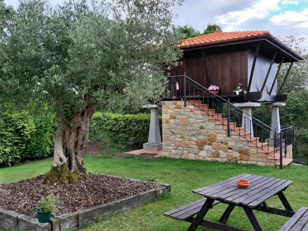 una mesa de picnic junto a un árbol y un cenador en Somonte, en Quintes