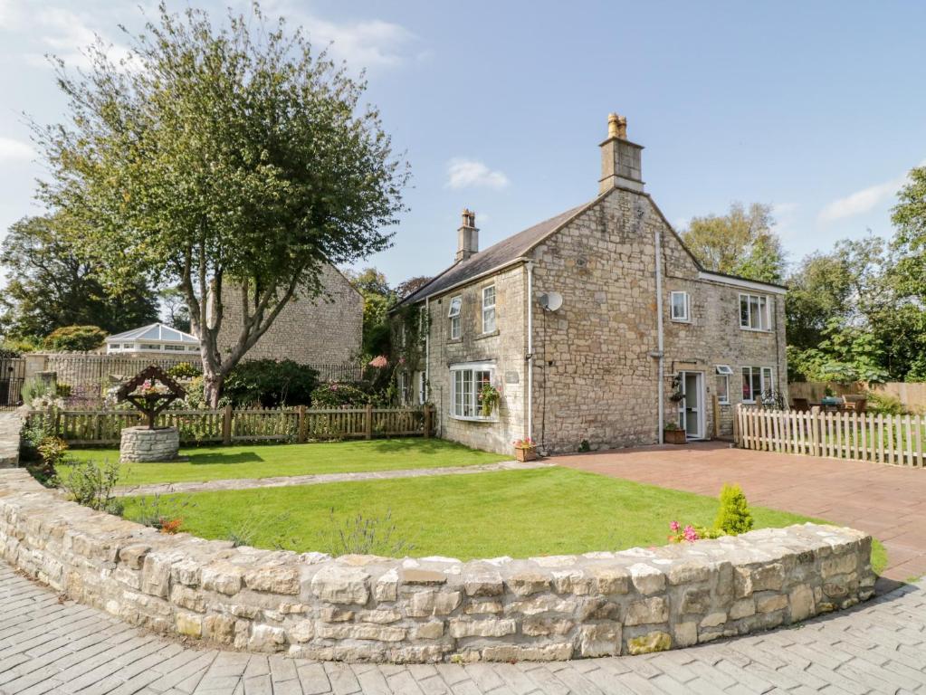 una antigua casa de piedra con un gran patio en Crooked Well en Bath