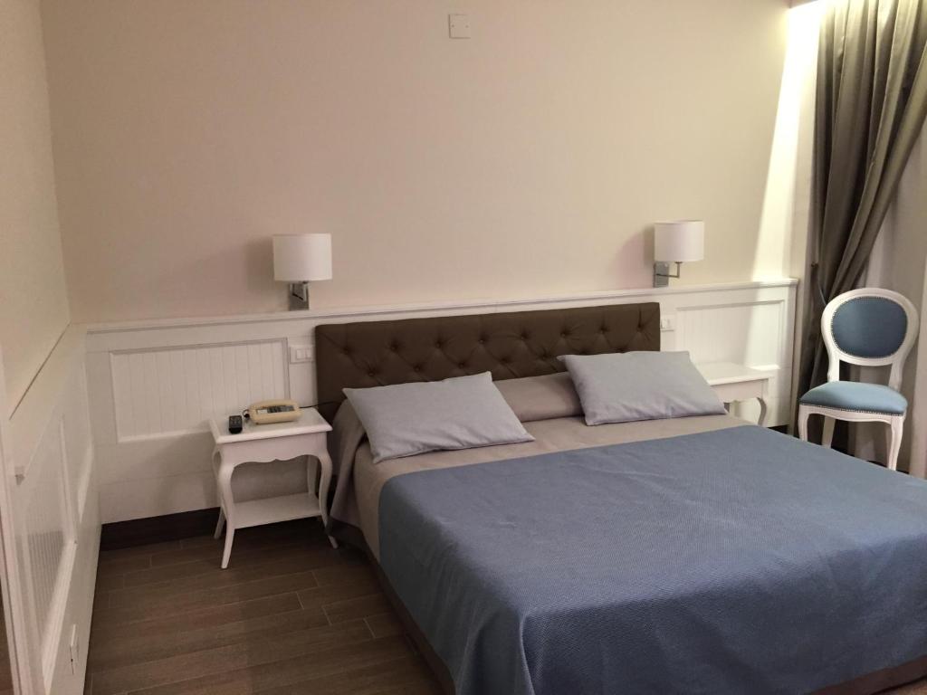1 dormitorio pequeño con 1 cama y 1 silla en Grand Hotel Montesilvano, en Montesilvano