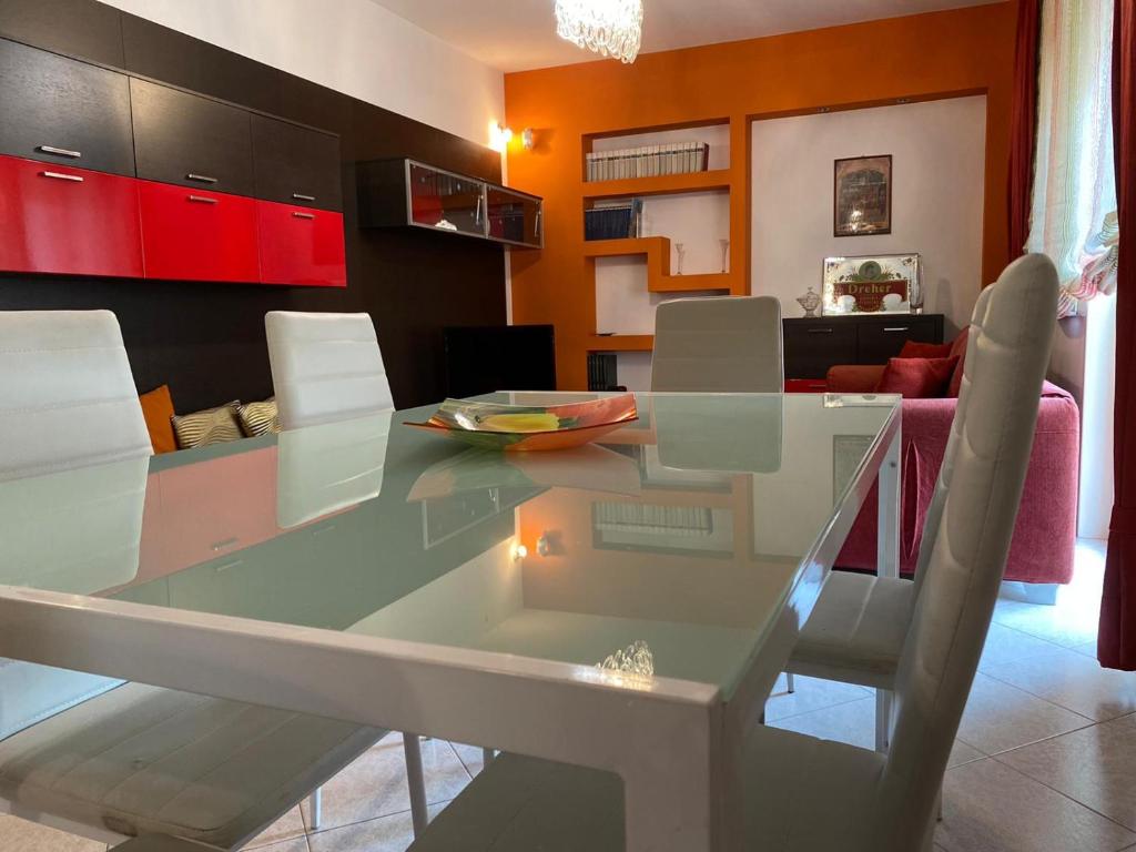 una mesa de cristal y sillas en la sala de estar. en Casa Vacanze Sciascia, en Monforte San Giorgio Marina