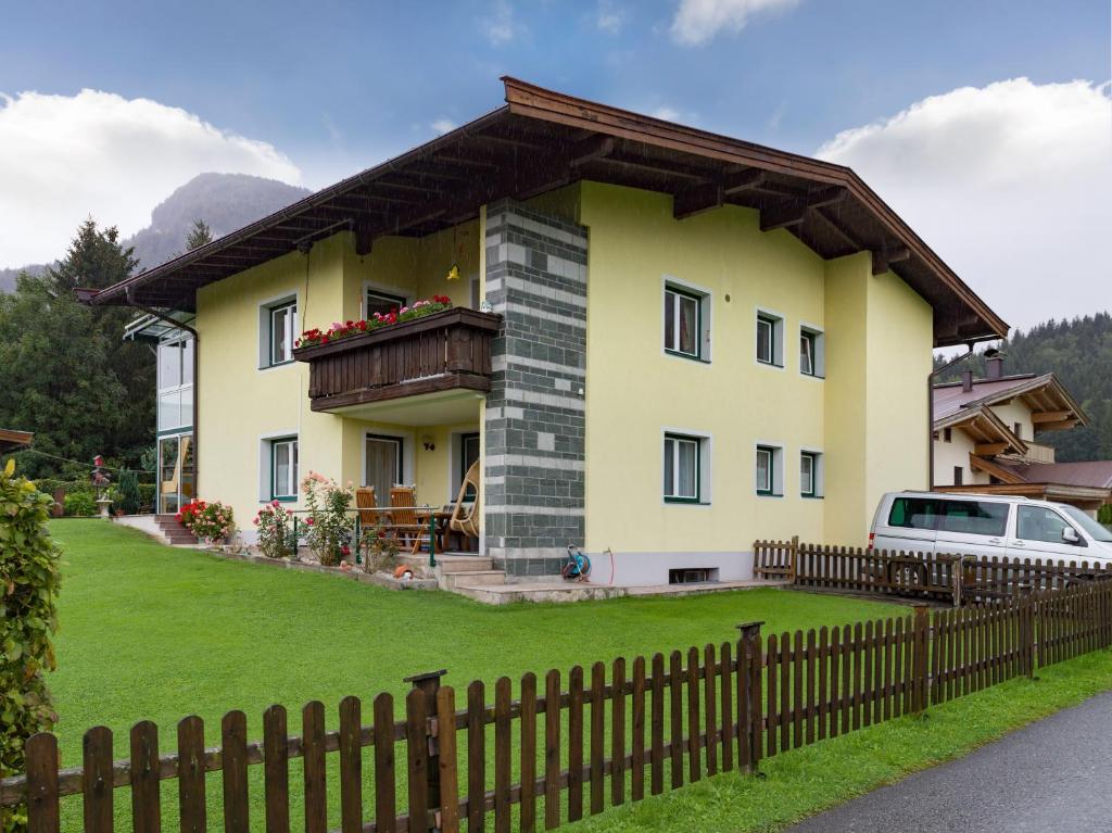 una casa amarilla con una valla delante de ella en Haus Laimbauer, en Kirchdorf in Tirol