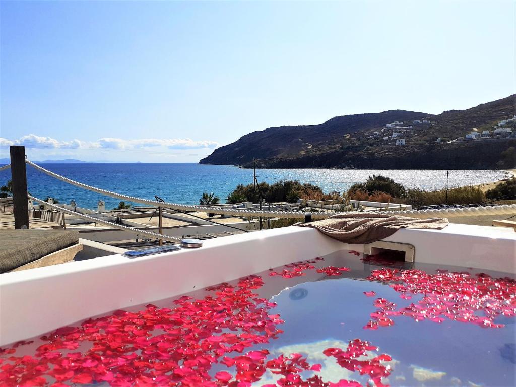 a bath tub filled with red flower petals at Sea Side Studios & Houses in Kalo Livadi