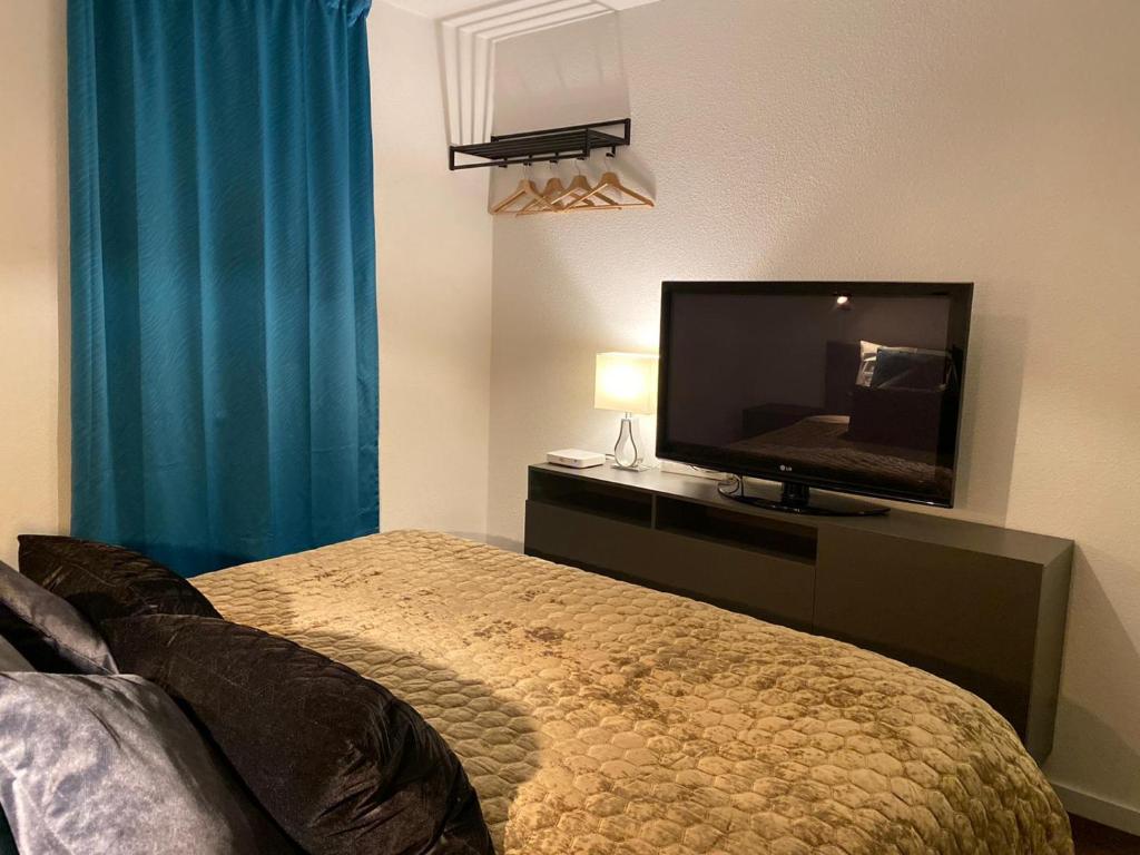 a bedroom with a bed and a flat screen tv at B&B by the C in Vlissingen