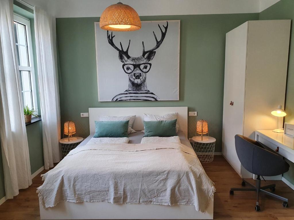 Dormitorio con cama con cabeza de ciervo en la pared en Apartment 23 en Coburg