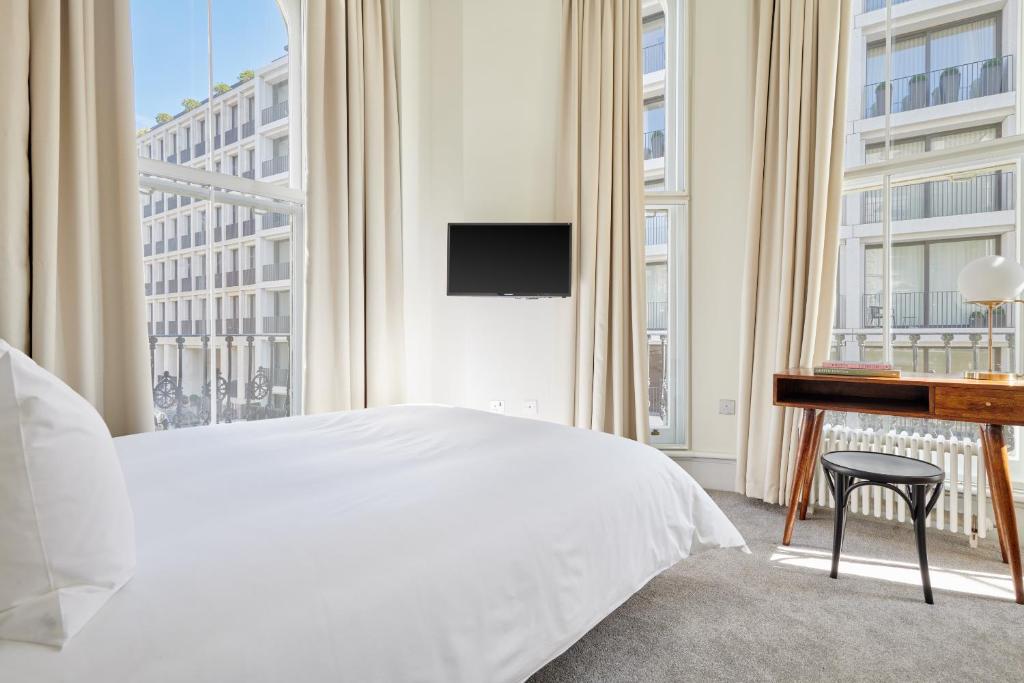 a hotel room with a bed and a tv at Sonder Kensington Gardens in London