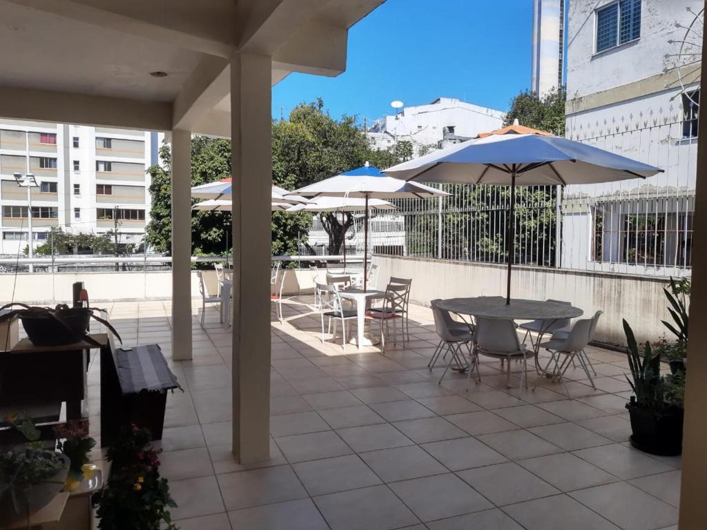 a patio with a table and chairs and umbrellas at Hostel My Place Hospedaria in Salvador