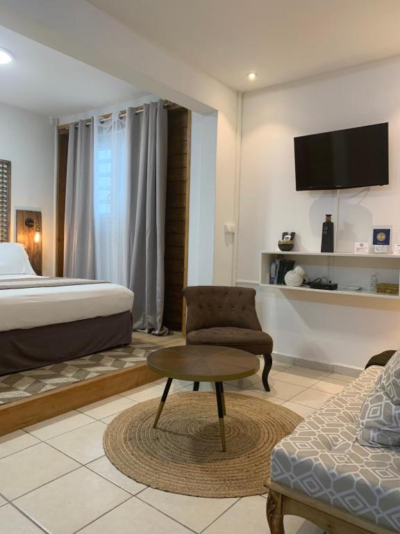 une chambre d'hôtel avec un lit et une chaise dans l'établissement Locastudio - Carambole, à Sainte-Anne