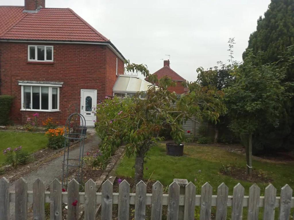 a white fence in front of a house at Great base for a Yorkshire adventure in Old Malton