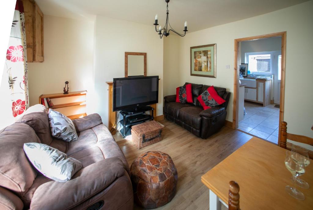 a living room with a couch and a tv at Charming terraced cottage close to Alton Towers in Cheadle