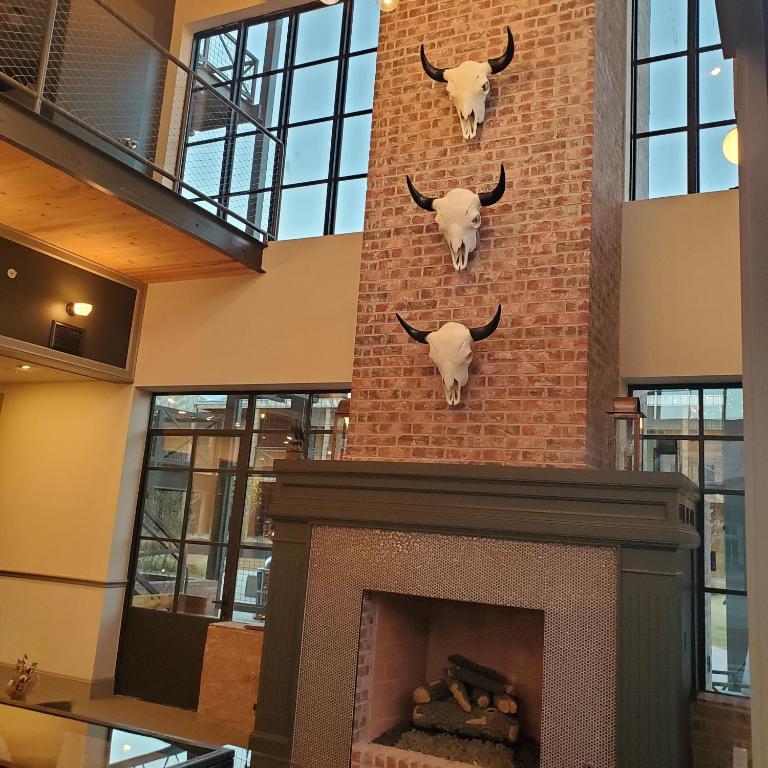 a fireplace with two bulls on a brick wall at Cotton Court Hotel, by Valencia Hotel Collection in Lubbock