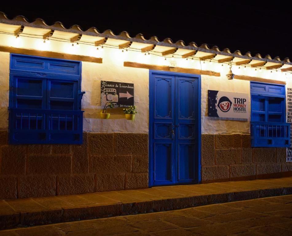 twee blauwe deuren aan de zijkant van een gebouw 's nachts bij Hostel Trip Monkey Barichara in Barichara
