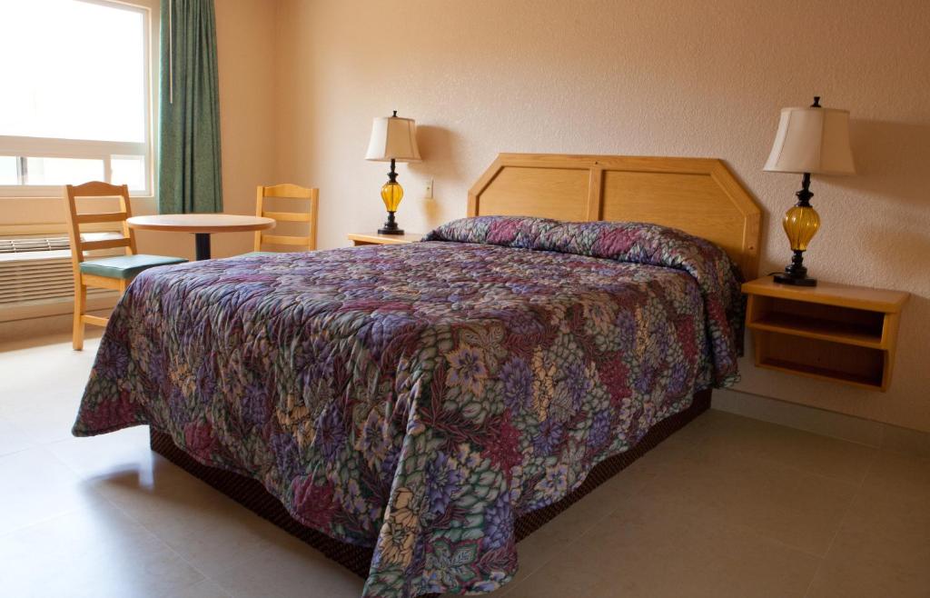 a hotel room with a bed and two lamps at La Villa De San Quintin in San Quintín