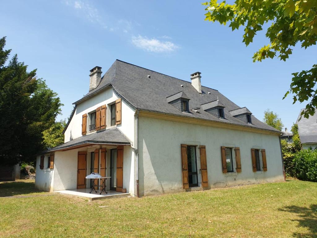 Biały dom z szarym dachem w obiekcie La bergerie, maison spacieuse avec grand jardin, vue sur les Pyrénées w Lourdes