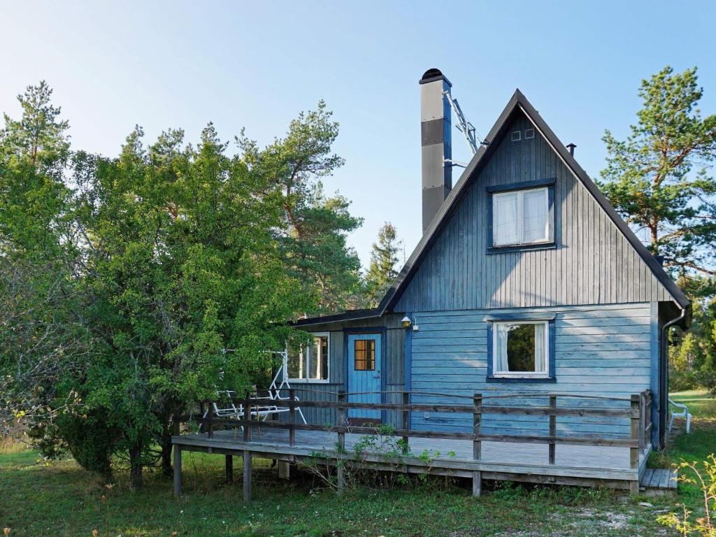 een blauw huis met een veranda en een dak bij 4 person holiday home in L RBRO in Lärbro