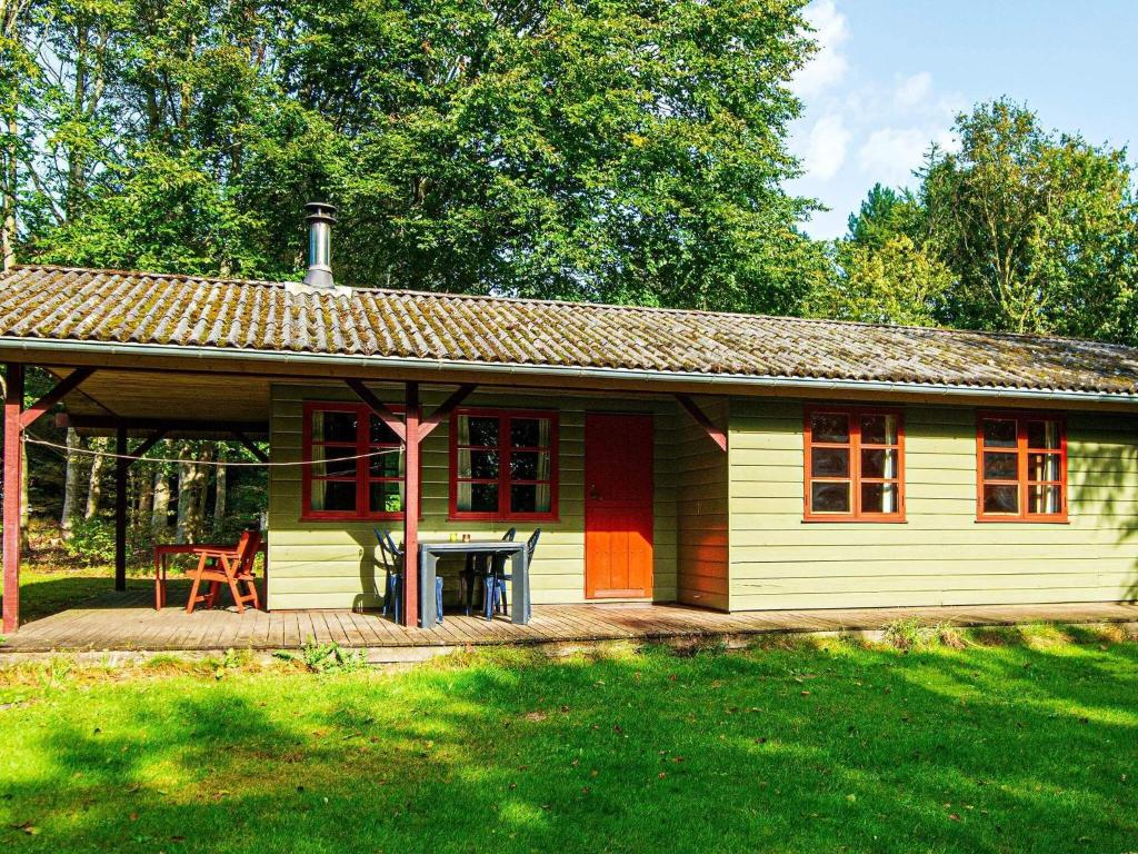 ArrildにあるThree-Bedroom Holiday home in Toftlund 25の庭にデッキがある小さな黄色の家