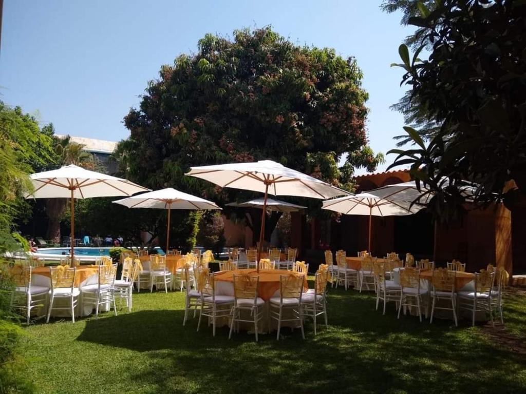 un grupo de mesas y sillas con sombrillas en HOTEL QUINTA DEL DESCANSO, en Cuautla Morelos