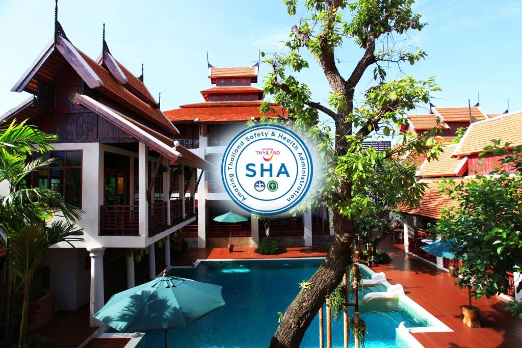 un hotel con piscina frente a un edificio en The Rim Chiang Mai, en Chiang Mai