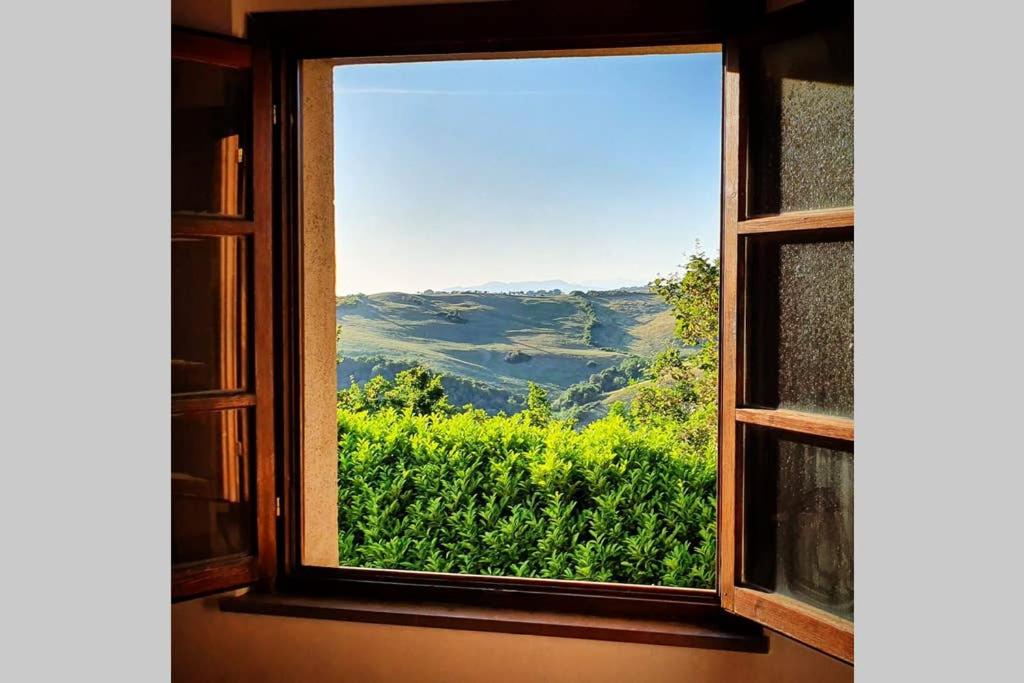 an open window with a view of a field of crops at Appartamento Il Nido in Volterra