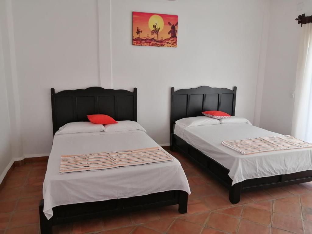 a bedroom with two beds and two lamps at Hotel Tiktaalik in Puerto Escondido