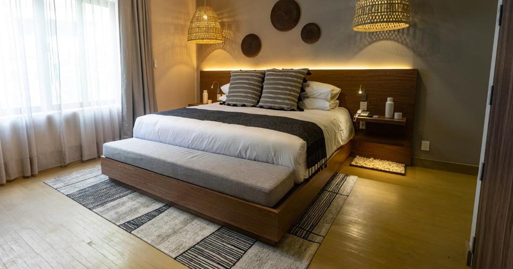 
a bed room with a large bed and a large window at Agata Hotel Boutique & Spa in Mexico City
