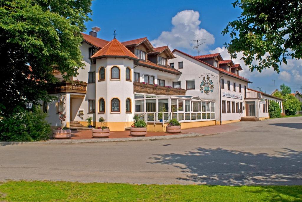 un gran edificio blanco con techo rojo en Hotel Zum Fischerwirt, en Baindlkirch