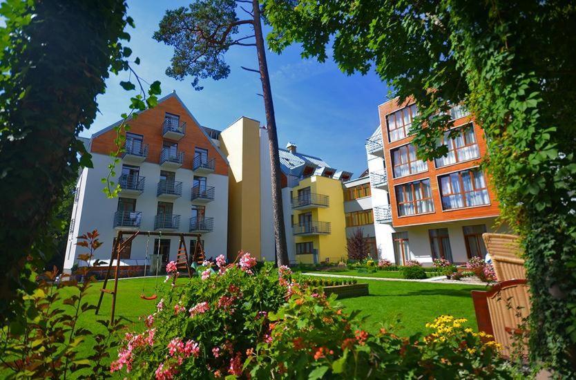 a group of buildings in a yard with flowers at Rezydencja Familia in Świnoujście